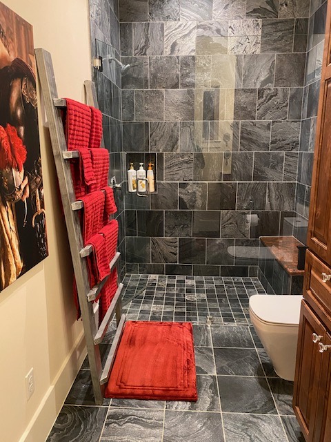 Private bathroom with a tiled walk-in shower and red towels