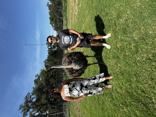 Guests beside an ostrich on the ranch
