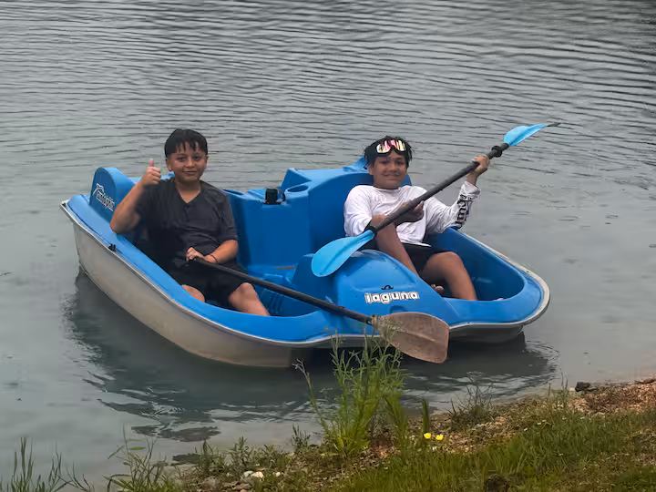 Two guests paddling together on the pond