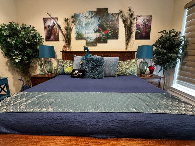 Blue bedding and peacock artwork in the Peacock Forest Room